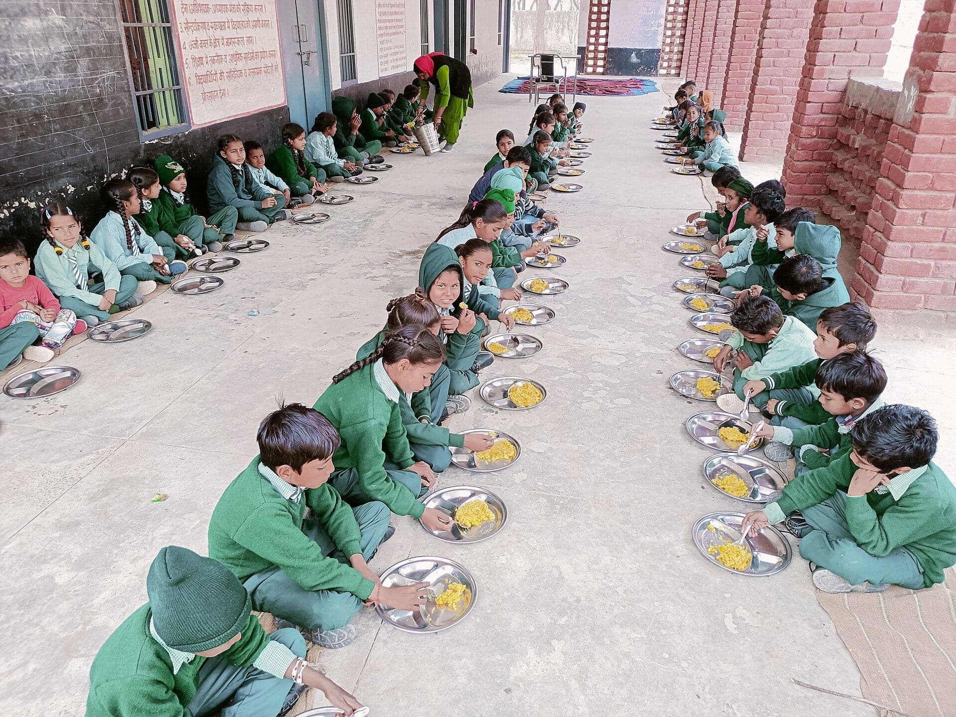 Schoolchildren sitting in rows for a midday meal